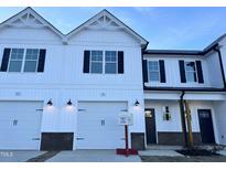Modern white two-story townhome with two-car garage at 91 Calluna Dr, Clayton, NC 27520
