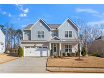 Two-story house with gray and beige siding, white garage door, and landscaping at 78 N Porcenna Ln, Clayton, NC 27527