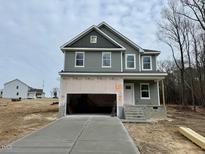 Two-story gray house with attached garage and concrete driveway at 45 Covey Rise Way, Lillington, NC 27546