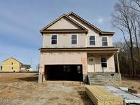 Two-story house with wrap-around porch, two-car garage, and large windows at 45 Covey Rise Way, Lillington, NC 27546