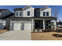 Two-story home with gray siding, white accents, and a two-car garage at 453 Edison Rail Ln, Knightdale, NC 27545