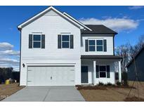 Two-story white house with gray shutters, double garage, and landscaping at 4900 Pioneer Dr, Sanford, NC 27330