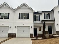 Charming two-story home with white siding, black trim, and attached garage at 136 S Mistflower St, Clayton, NC 27520