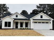 Charming white two-story farmhouse with a two-car garage and a covered front porch at 601 Vannoy Pl, Fuquay Varina, NC 27526