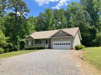 House exterior featuring a two-car garage and gravel driveway at 2130 Detroit Blvd, Sanford, NC 27332