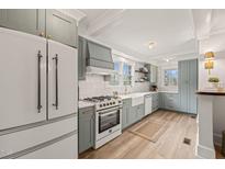 Renovated kitchen featuring white appliances and soft blue cabinets at 320 W Orange St, Hillsborough, NC 27278