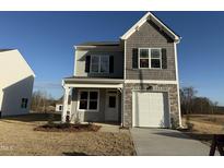 Two-story house with gray siding, white garage door, and landscaping at 346 Tormore, Homesite 125, Sanford, NC 27330