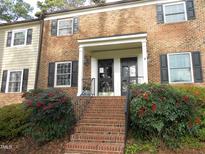 Front exterior of a two-story brick condo building with stairs, shrubs, and double door entryway at 3738 Jamestown Cir, Raleigh, NC 27609