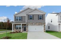 New two-story home with stone accents, front porch, and attached two-car garage at 432 Ashley Run, Sanford, NC 27330