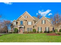 Stately brick home with stone accents, manicured lawn, and welcoming front porch at 4109 Cheek Point Pl, Burlington, NC 27215