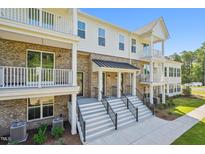 Inviting townhome exterior with dual entry stairs, balconies, and brick accents at 11548 Helmond Way # 118, Raleigh, NC 27617