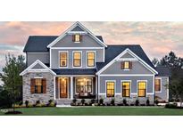 Two-story home with gray siding, stone accents, and a landscaped lawn at 259 August Trce Dr, Pittsboro, NC 27312