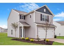 Charming two-story home with gray siding, white garage door, and landscaped front yard at 604 Rhino Bnd, Oxford, NC 27565
