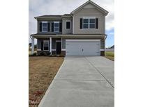 Two-story house with gray siding, white garage door, and landscaping at 82 Vili Dr, Broadway, NC 27505