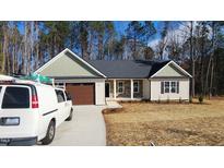 New construction home with neutral siding, stone accents, and a two-car garage at 125 Leisure Ln, Louisburg, NC 27549