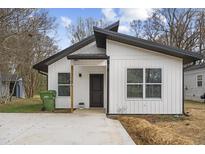 Modern white house with dark gray roof and a small front yard at 316 Field St, Graham, NC 27253