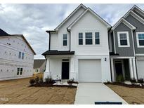 Two-story townhome with white siding and a gray accent wall at 523 Eversden Dr, Zebulon, NC 27597
