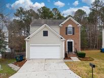 Two-story brick and beige home with a two-car garage and well-manicured lawn at 210 Pebblestone Dr, Durham, NC 27703