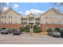 Beige multi-unit building with brick accents, ample parking, and landscaping at 524 Glenolden Ct, Cary, NC 27513