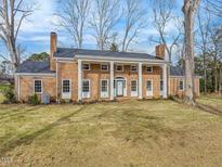 Brick house with columns, large windows, and a spacious lawn at 191 Pine Lake Dr, Siler City, NC 27344