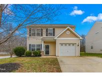 Two-story house with beige vinyl siding, a white garage door, and a well-maintained lawn at 722 Blue Lake Dr, Mebane, NC 27302