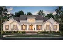 Stunning farmhouse exterior with large windows and a welcoming front porch at 2308 Hardwood Dr, Hillsborough, NC 27278