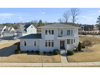 Two-story house with gray siding, multiple windows, and a landscaped yard at 235 Cottage Way, Pittsboro, NC 27312