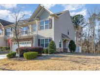 Two-story townhome boasting a neutral exterior, landscaped yard, and attached garage at 2722 Evanston Ave, Durham, NC 27703