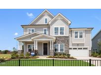 Two story house with gray siding, stone accents, and a three-car garage at 111 E Fountainhead Ln # 154, Garner, NC 27529