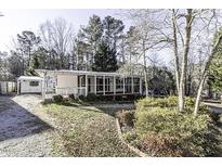 Single-wide manufactured home with screened porch and storage shed at 138 Running Deer Dr, Louisburg, NC 27549