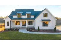 Stunning farmhouse exterior boasts a metal roof and charming front porch at 3804 Laurel Hills Rd, Raleigh, NC 27612