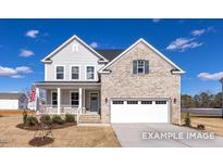 Two-story house with gray siding, brick accents, and a two-car garage at 409 Reinsman Ct, Mebane, NC 27302