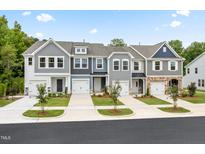 Four townhouses with gray siding, two-car garages, and landscaping at 6334 Lady Eliza Ln, Raleigh, NC 27610