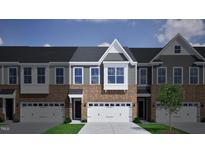 Two story townhome with gray and brick exterior, two-car garage, and landscaping at 1034 Westerland Way # 210, Durham, NC 27703