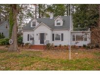 Charming white house with a gray roof and manicured lawn at 421 S Morgan St, Roxboro, NC 27573