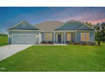 New single-story home with gray siding, two-car garage, and landscaped lawn at 587 Glenkirk Pl, Garner, NC 27529