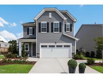 Two-story gray house with white garage door and landscaping at 601 Emerald Bay Cir, Raleigh, NC 27610