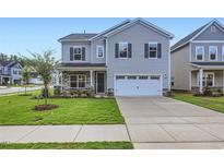 Two-story house with gray siding, stone accents, and a two-car garage at 604 Emerald Bay Cir, Raleigh, NC 27610