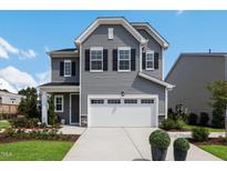 Two-story gray house with white garage door and landscaping at 609 Emerald Bay Cir # 813, Raleigh, NC 27610