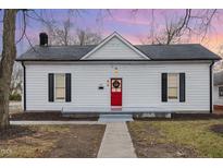 Charming white bungalow with red door, gray walkway, and well-maintained lawn at 334 E Andrews Ave, Henderson, NC 27536