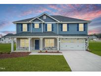 Two-story house with blue siding, stone accents, and a large front porch at 590 Glenkirk Pl, Garner, NC 27529