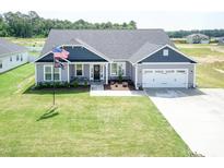 Gray two-story house with a two-car garage and manicured lawn at 104 Newport Landing Lndg # 100, Garner, NC 27529