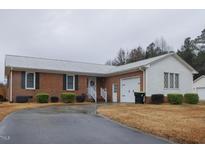 Brick ranch house with attached garage and landscaped yard at 202 S Wilson St, Kenly, NC 27542