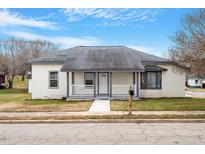 Charming renovated bungalow with a white brick facade, gray roof, and a welcoming front porch at 115 Kerr Dr, Roxboro, NC 27573