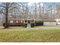 Tan mobile home with red shutters, front porch, and landscaped yard at 1705 Old Nc 10 Hwy, Hillsborough, NC 27278