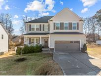 Two-story house with gray siding, a large garage, and a well-manicured lawn at 38 Hiddenbrook Ct, Angier, NC 27501