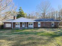 Brick ranch house with covered porch and large yard at 1354 Mudham Rd, Wendell, NC 27591