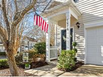 Inviting exterior featuring a charming front porch and well-manicured landscaping at 1674 Snowmass Way, Durham, NC 27713