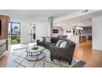 Open living area with curved sofa, coffee table, and view into modern kitchen at 523 S West St # 402, Raleigh, NC 27601