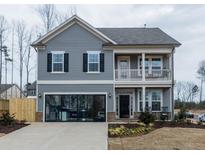 Two story home with gray siding, black shutters, and a three car garage at 817 Heartpine Dr, Mebane, NC 27302